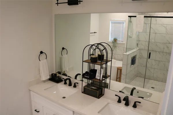 a bathroom with a sink a mirror and shower