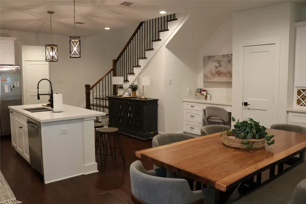a living room with a sink dishwasher and a dining table with wooden floor