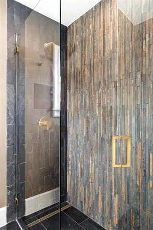 a bathroom with a granite countertop sink and shower