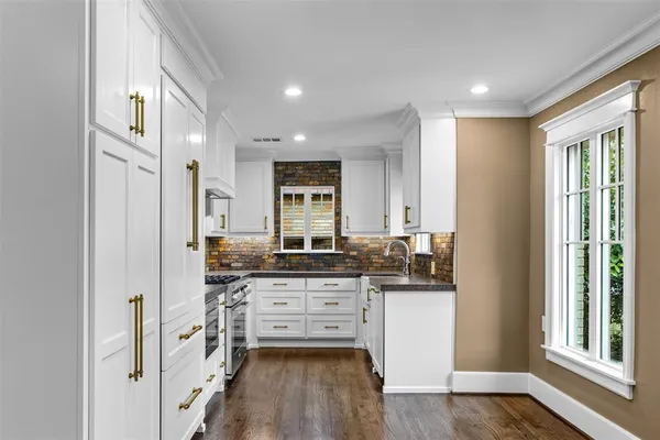 a kitchen with stainless steel appliances a stove and cabinets