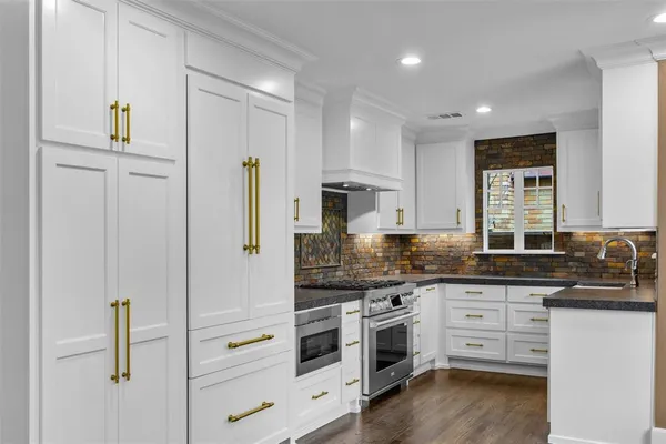a kitchen with white cabinets and stainless steel appliances
