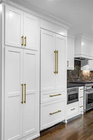 a kitchen with stainless steel appliances white cabinets and wooden floors