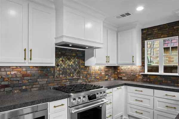 a kitchen with white cabinets and appliances