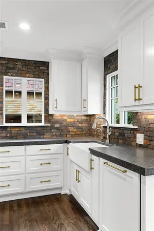 a kitchen with granite countertop a sink and cabinets