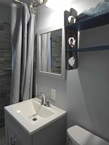 a bathroom with a toilet sink and mirror