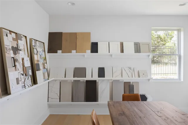 a living room with stainless steel appliances furniture a fireplace and a large window