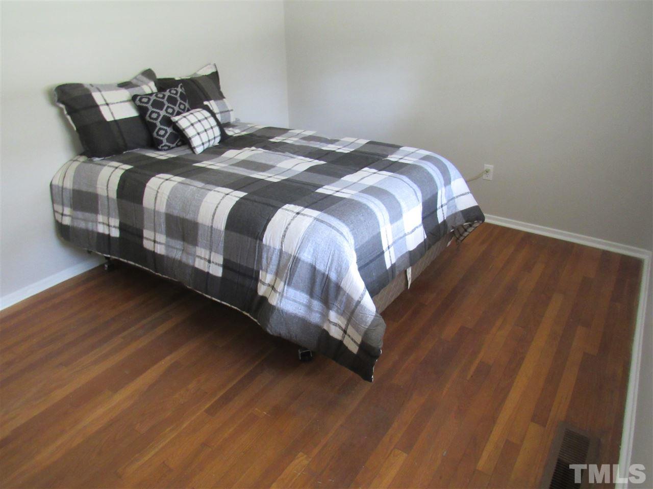 321 Quail Drive Raleigh, NC 27604 - Photo 12 of 25 a bedroom with a bed and wooden floor
