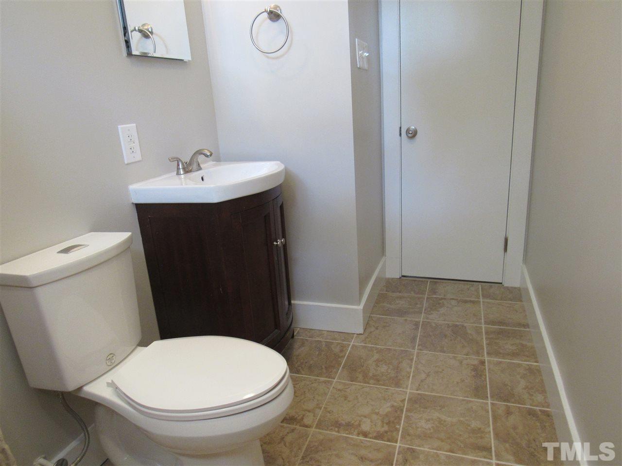 321 Quail Drive Raleigh, NC 27604 - Photo 19 of 25 a bathroom with a toilet a sink and mirror