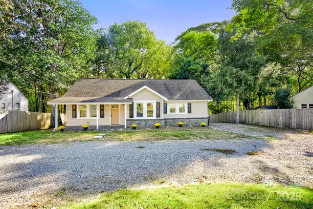 a front view of a house with a yard and trees