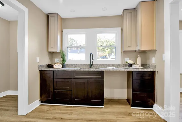 a kitchen with stainless steel appliances granite countertop a sink and cabinets with wooden floor