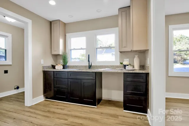 a kitchen with granite countertop a refrigerator and window