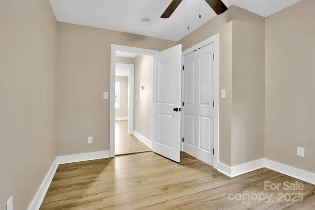 a view of empty room with wooden floor