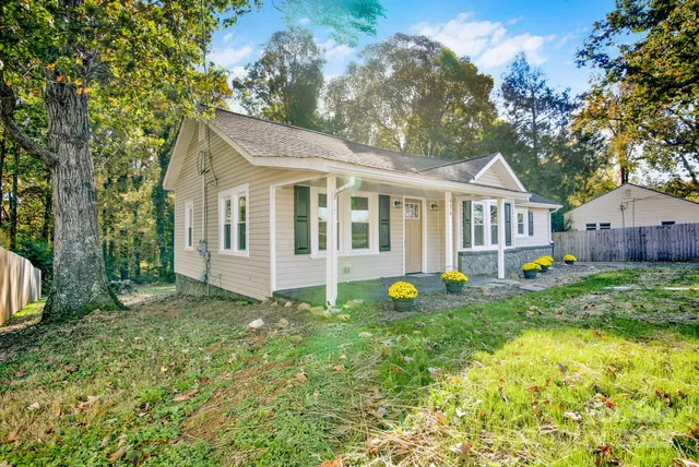 a view of a house with a backyard and a tree