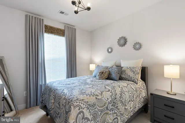 a bedroom with a bed and a lamp on dresser