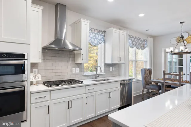 a kitchen with granite countertop a sink stainless steel appliances and cabinets