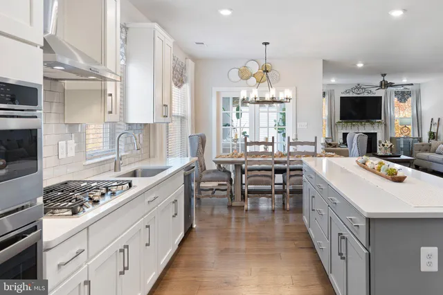a kitchen with kitchen island granite countertop a sink stove and cabinets