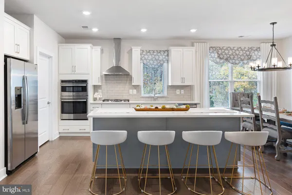 a kitchen with a dining table chairs refrigerator and cabinets