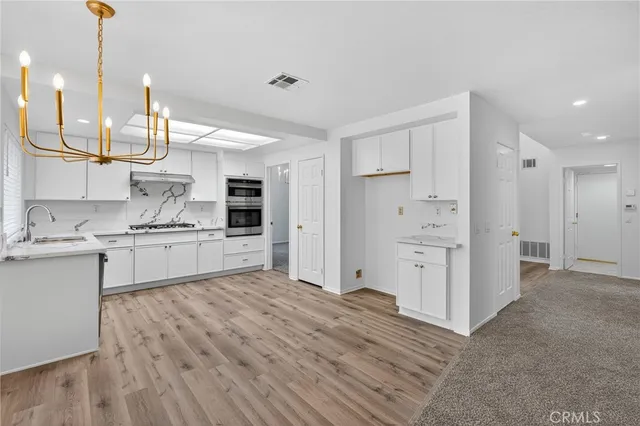 a kitchen with kitchen island white cabinets and stainless steel appliances