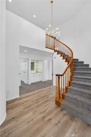 a view of staircase with wooden floor and a chandelier