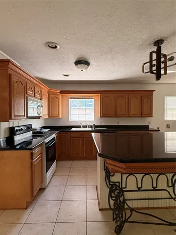 a kitchen with a stove a sink and a microwave