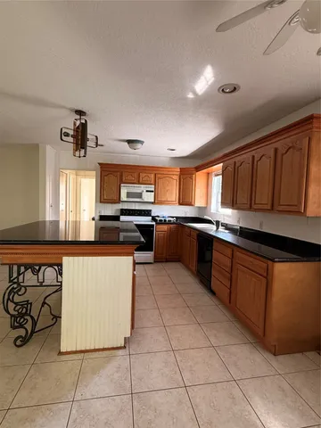 a large kitchen with stainless steel appliances granite countertop a stove and cabinets