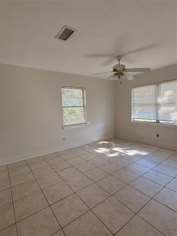 a view of empty room with window and ceiling fan