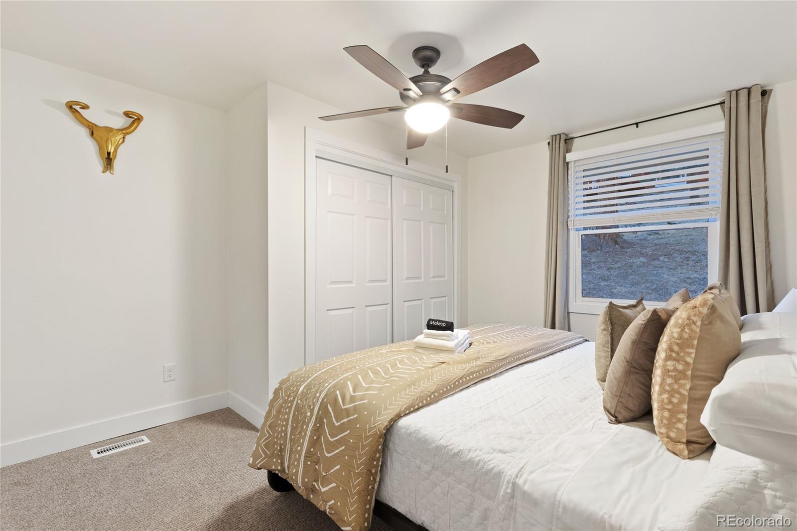 29 South Pine Drive Bailey, CO 80421 - Photo 20 of 27 a bedroom with a bed and a chandelier