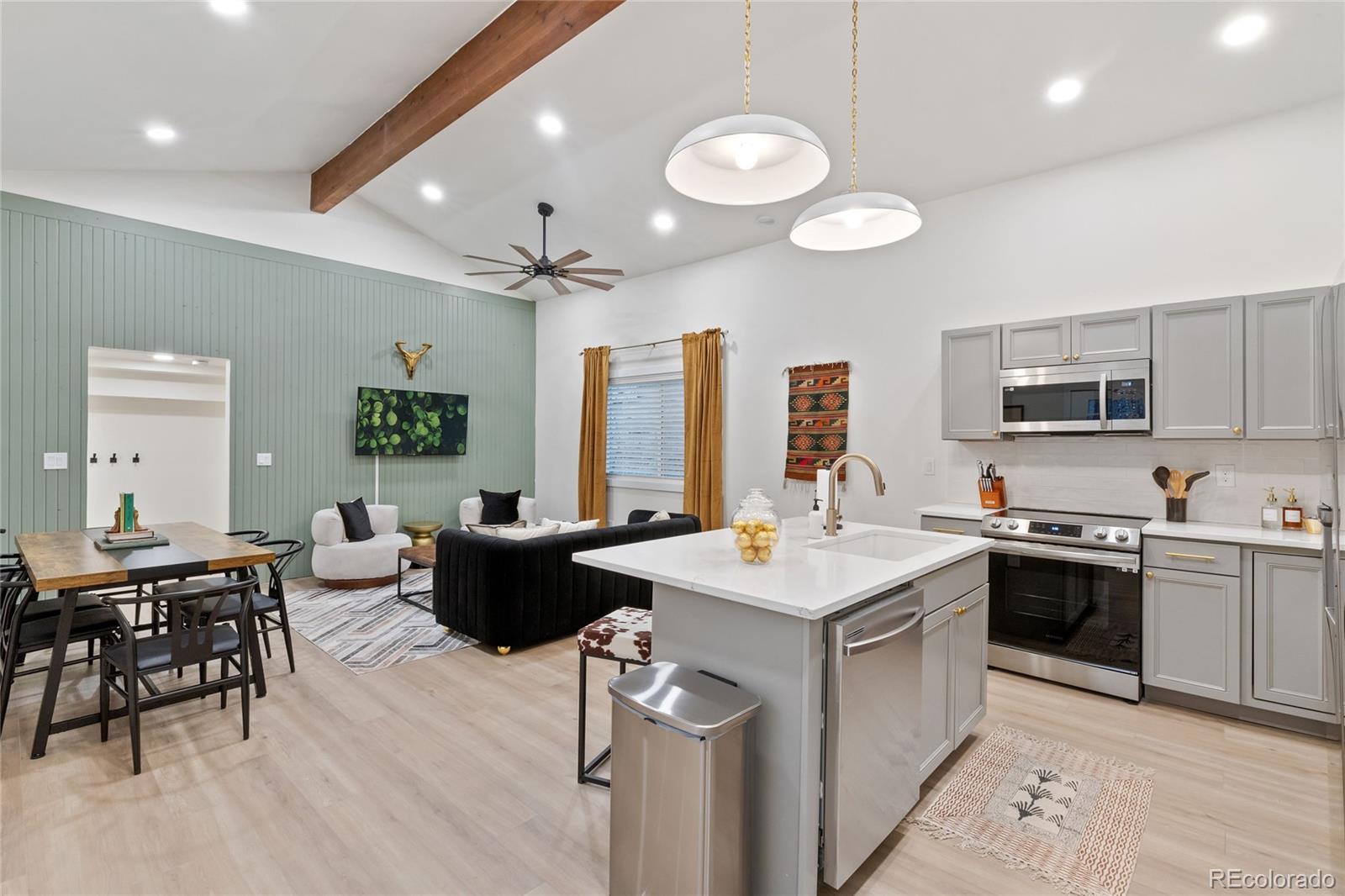 29 South Pine Drive Bailey, CO 80421 - Photo 3 of 27 a kitchen with a stove a sink a kitchen island with chairs and wooden floor