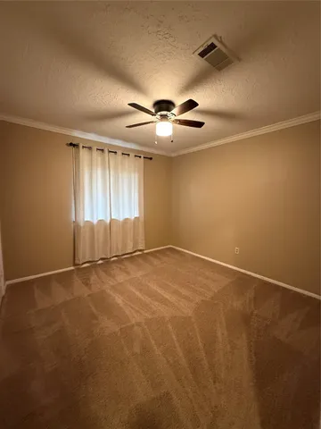 an empty room with windows and chandelier fan