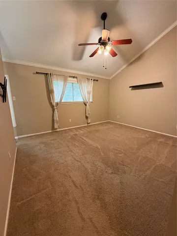 an empty room with ceiling fan and window