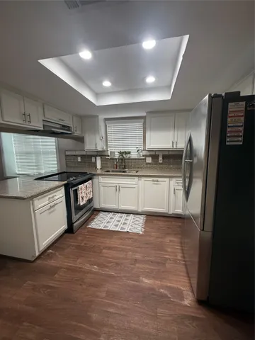 a kitchen with stainless steel appliances granite countertop a stove a sink and a refrigerator