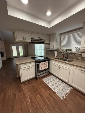 a kitchen with stainless steel appliances kitchen island granite countertop a sink stove and cabinets