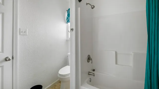 a bathroom with a granite countertop toilet and a shower