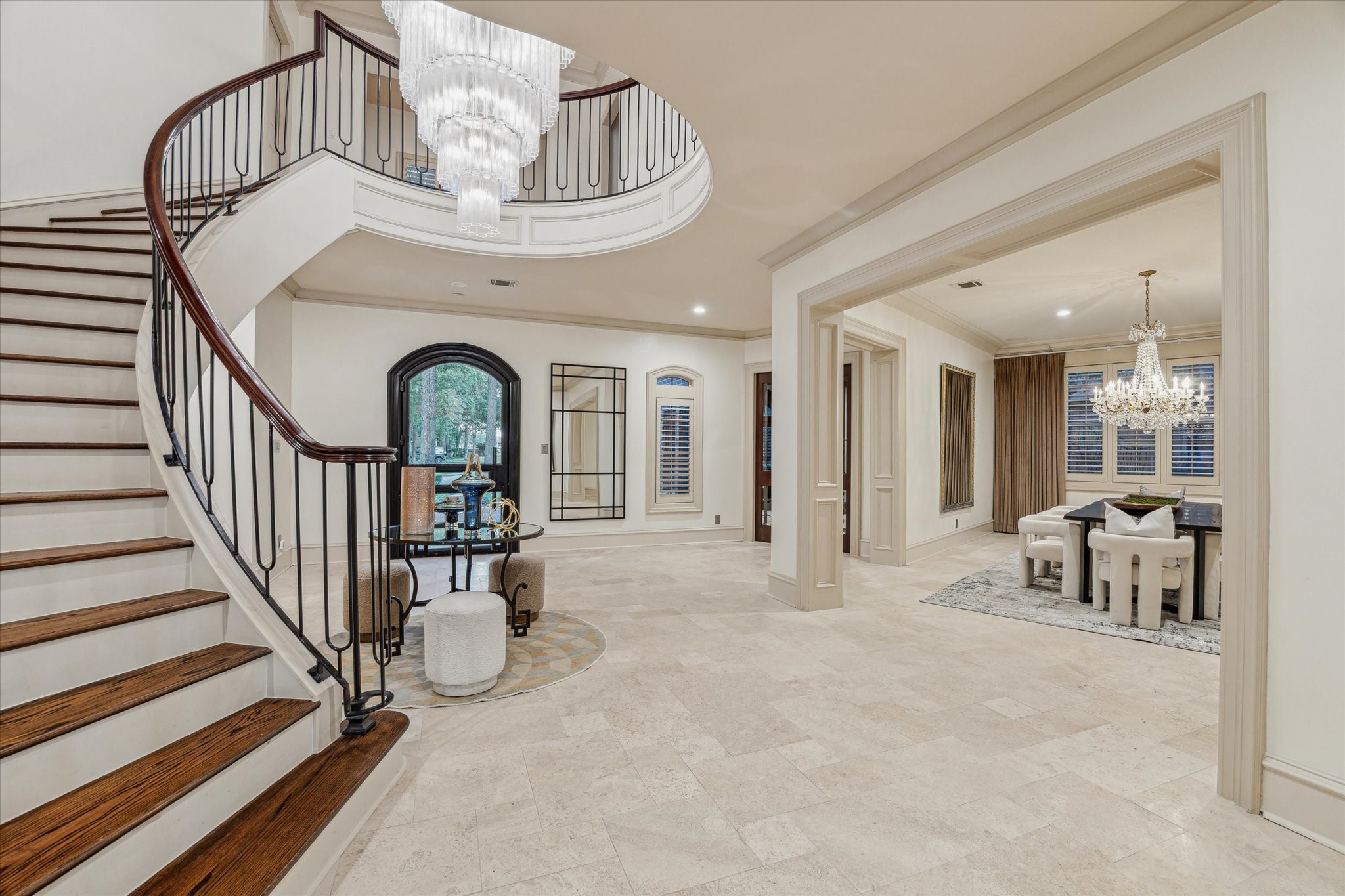 918 Huntington Cove Houston, TX 77063 - Photo 8 of 50 A different perspective of the grand foyer capturing the graceful curve of the spiral staircase and a glimpse of a framed opening looking into the formal dining room