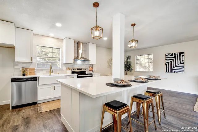 a kitchen with stove a table and chairs in it