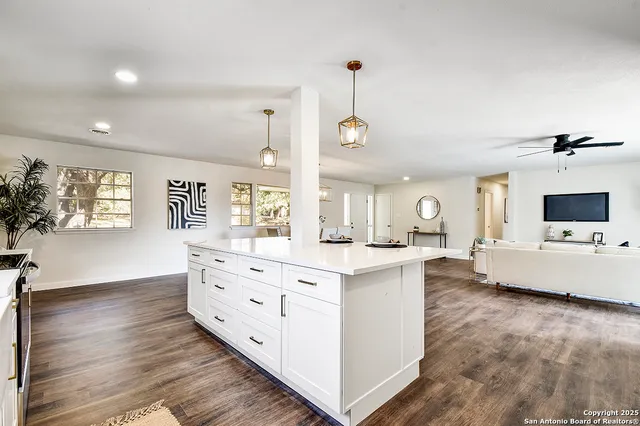 a large white kitchen with a large window