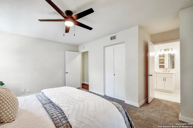 a bedroom with a bed and a ceiling fan