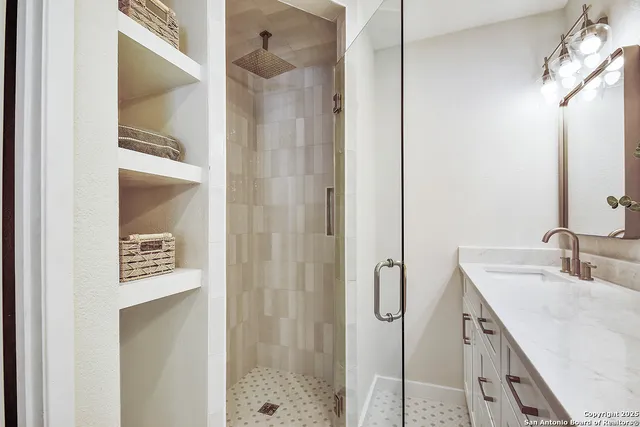 a bathroom with a shower sink and mirror