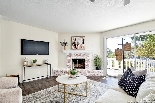 a living room with furniture a flat screen tv and a fireplace