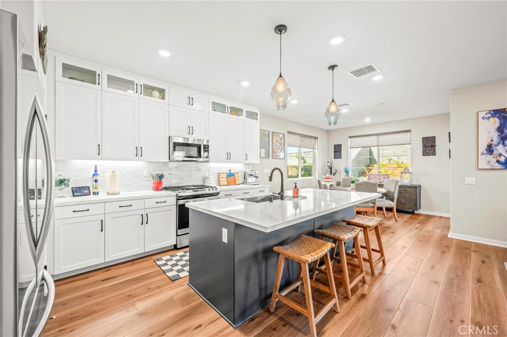 1281 Roots Way Rancho Mission Viejo, CA 92694 - Photo 14 of 75 a kitchen with stainless steel appliances kitchen island granite countertop a sink and cabinets