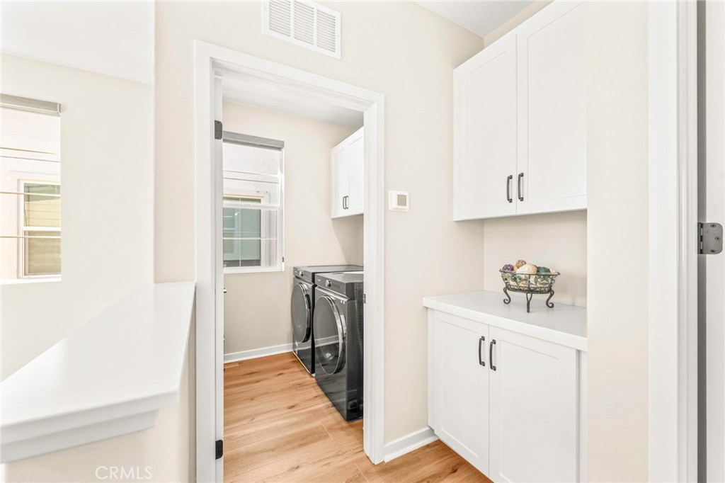 1281 Roots Way Rancho Mission Viejo, CA 92694 - Photo 30 of 75 a view of a kitchen with white cabinets and a refrigerator