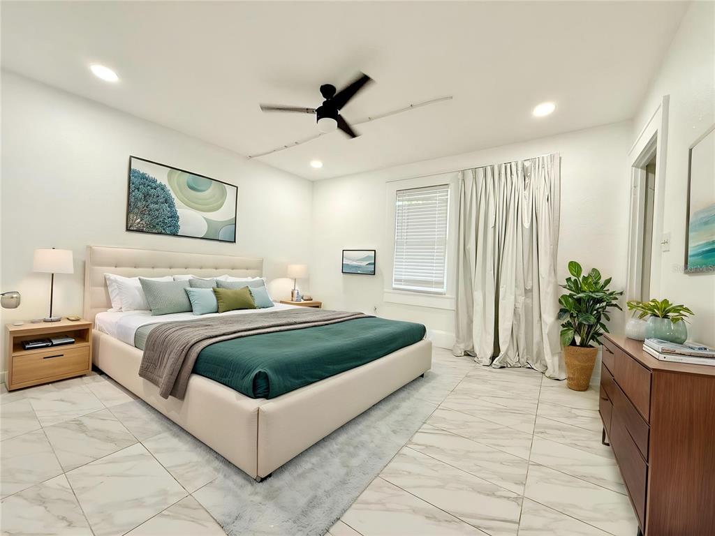 507 North Ridgewood Avenue, Unit 4 Daytona Beach, FL 32114 - Photo 2 of 7 a spacious bedroom with a bed and a potted plant