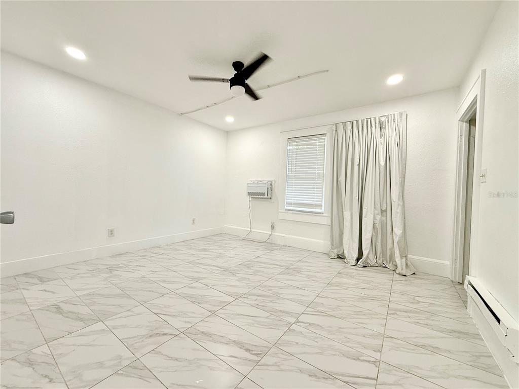 507 North Ridgewood Avenue, Unit 4 Daytona Beach, FL 32114 - Photo 3 of 7 a view of empty room with wooden floor and window