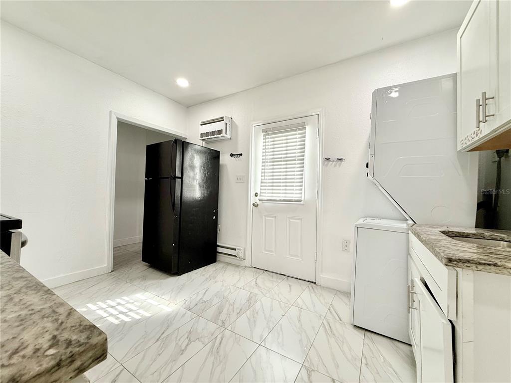 507 North Ridgewood Avenue, Unit 4 Daytona Beach, FL 32114 - Photo 5 of 7 a bedroom with a bed and a refrigerator