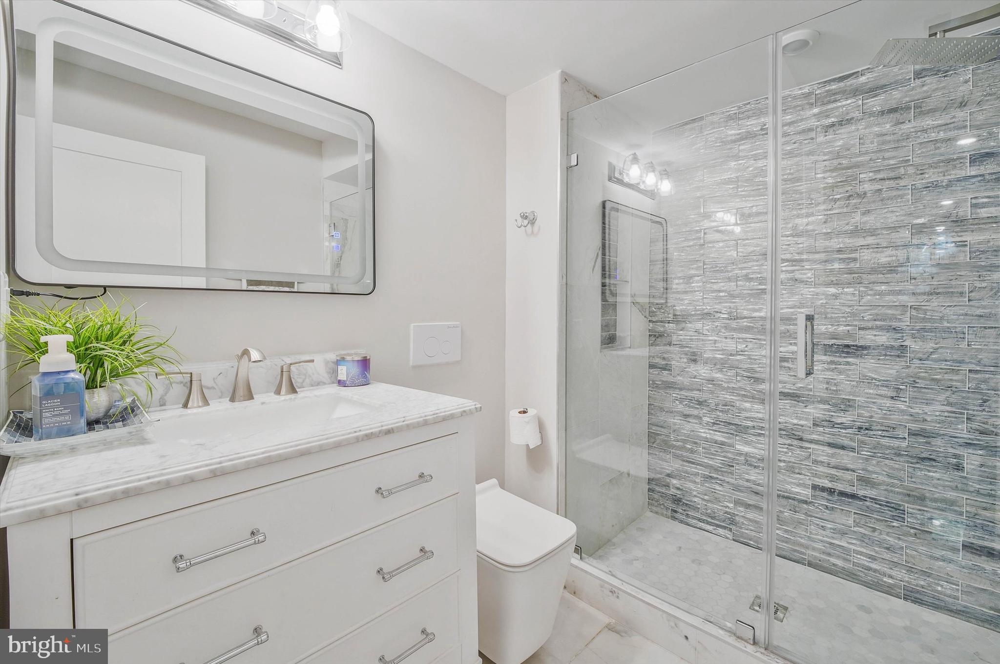 1240 Columbia Road Northwest, Unit 1 Washington, DC 20009 - Photo 10 of 25 a bathroom with a granite countertop sink mirror vanity and toilet