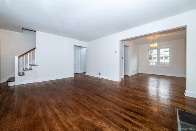 a view of a livingroom with wooden floor and stairs