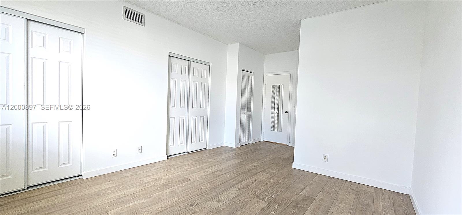46 Simonton Circle Weston, FL 33326 - Photo 11 of 14 an empty room with wooden floor and windows