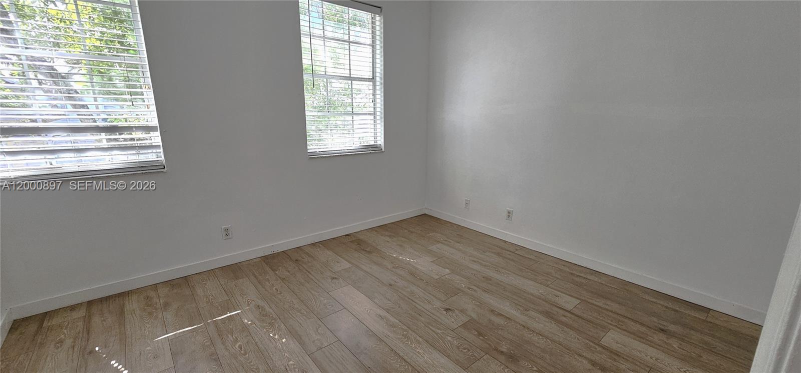 46 Simonton Circle Weston, FL 33326 - Photo 8 of 14 an empty room with wooden floor and windows