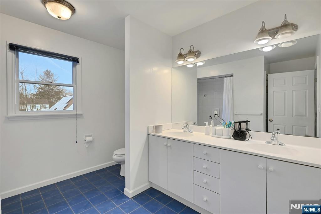 288 Schley Place Teaneck, NJ 07666 - Photo 16 of 29 a bathroom with a double vanity sink and a mirror