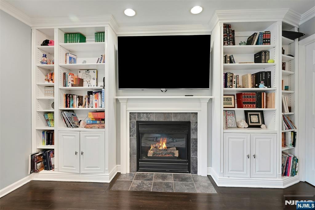 288 Schley Place Teaneck, NJ 07666 - Photo 7 of 29 a living room with a fireplace and a flat screen tv